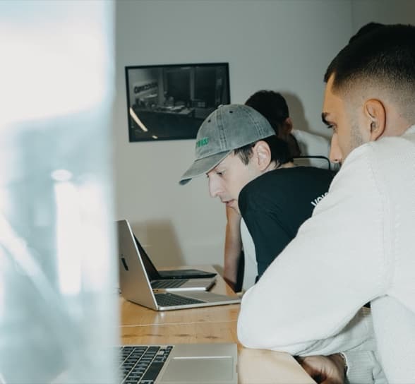 Two people working through a problem at one laptop